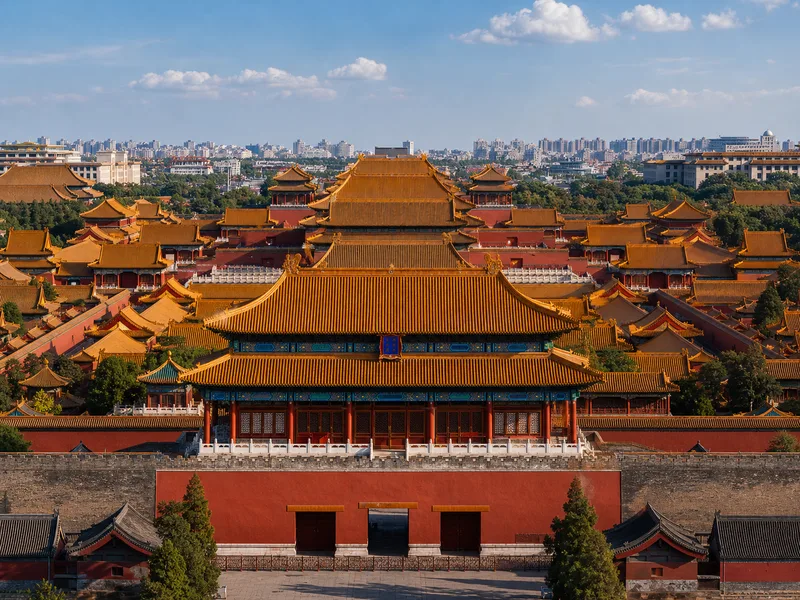 Visitors with a guide walking through a courtyard of the Forbidden City in Beijing on a Klook small group tour