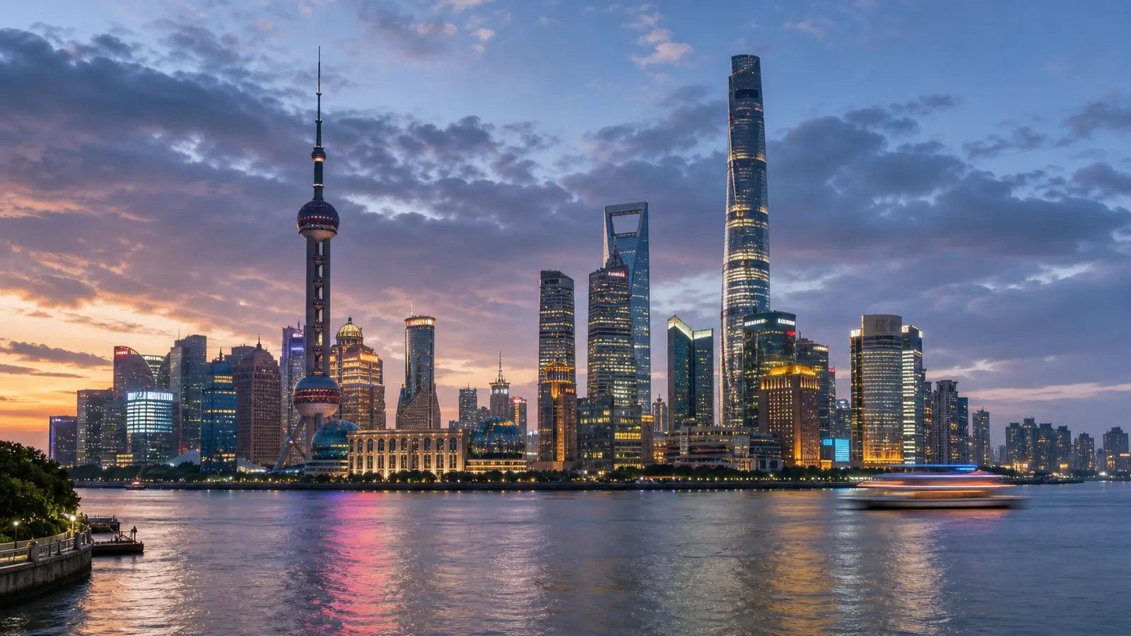 Shanghai Bund waterfront at dusk with the illuminated Lujiazui skyscrapers across the river