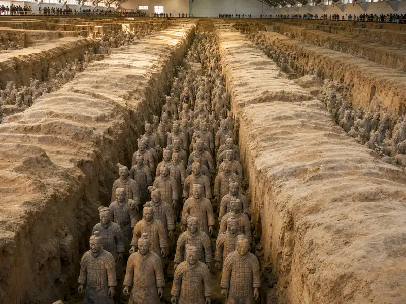 Tour group with a guide viewing the terracotta warriors from the walkway above the pits in Xian