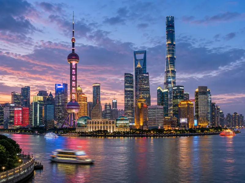 The Bund waterfront at night facing the illuminated Pudong skyline across the Huangpu River in Shanghai