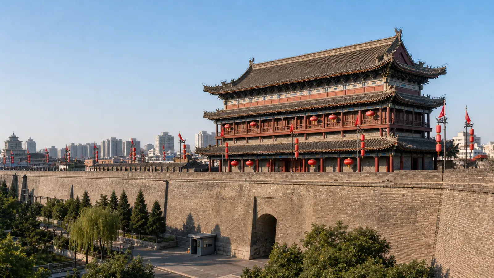 Cyclists riding along the top of the ancient Xi'an City Wall above the lit South Gate at dusk